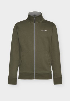 Olíva zöld cipzáras pulóver, puha anyagból készült. Magas gallérral, két elülső zsebbel, bordás mandzsettákkal, a mellrészen egy kis fehér logóval.