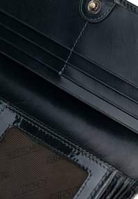 Czarny skórzany portfel z gładką fakturą, wieloma przegródkami na karty kredytowe i przezroczystym oknem na identyfikator z przeszyciem.