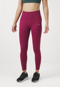 Mørkerøde ribbede leggings med høj talje, med logo detaljer. Kombinert med sorte atletiksko til aktivt brug.