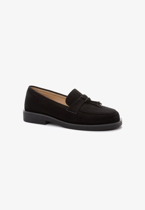 Black suede loafers featuring a simple bow accent, rounded toe, low block heel, and a smooth interior lining.