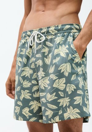 Schwimmshorts mit Blattmuster in schütterem Grün und cremefarbenen Blättern. Mit elastischem Bund und Kordelzug, seitlichen Taschen und glatter Textur.