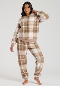 Braun-weiße Karomuster Fleece-Loungewear-Set bestehend aus einem Sweatshirt mit Rundhalsausschnitt und passenden Hosen. Weicher Stoff mit gerippten Bündchen.