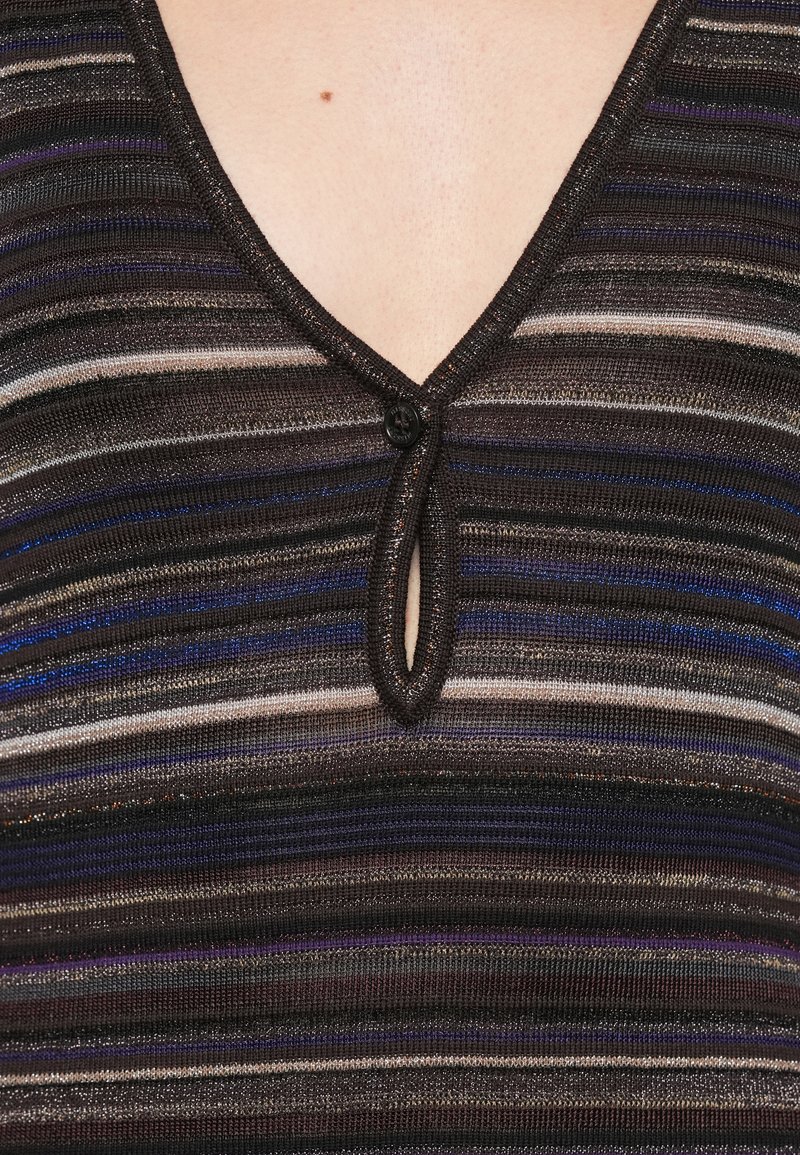 Haut en tricot avec un col en V et une fermeture à boutons, présentant des rayures horizontales dans des tons foncés, des accents argentés et bleus, en tissu texturé.
