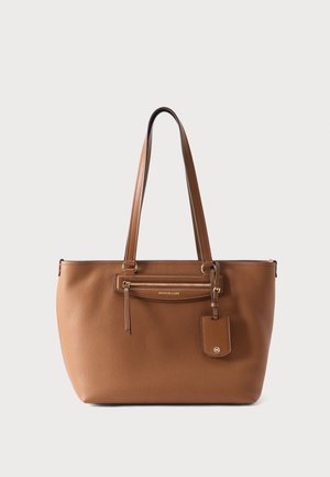 Brun læder shoppertaske med dobbelte skulderremme, forreste lynlåslomme og mærket hængende tag mod en ensfarvet baggrund.