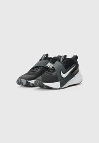 Čierne športové topánky s textúrovaným zvrškom, s šedým pásikom, bielym logom Swoosh a vzorovanou gumenou podrážkou.