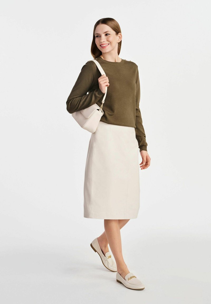 Oliwkowy sweter z długim rękawem, kremowa spódnica ołówkowa, jasnobeżowa torebka na ramię i beżowe mokasyny z złotymi akcentami.