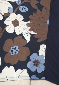 Tessuto a stampa floreale con grandi fiori bianchi, blu e marroni su uno sfondo blu navy scuro, con una finitura liscia e texture.