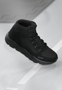 A fekete magasszárú sneaker texturált felsőrésszel, megerősített bokával, fűzős záródással és logós gumitalppal rendelkezik az oldalon.