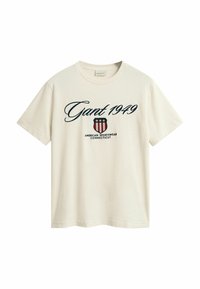 Cremefarvet bomulds t-shirt med et marineblåt print: "Gant 1949," et skjoldlogo med røde og hvide striber og "American Sportswear Connecticut."