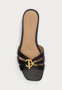 Juodos odinės šlepetės su kryžminėmis juostelėmis, kvadratine nosimi ir auksiniu apvaliu sagtimi. Yra šviesiai kreminė vidpadis su iškilniu logotipu.