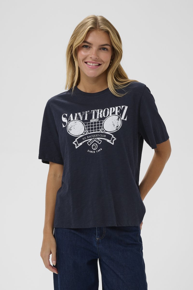 Laivo mėlynos spalvos medvilninis marškinėliai trumpomis rankovėmis, su balta grafika, vaizduojančia teniso raketes, ir užrašu "Saint Tropez" laisvos formos dizaino.