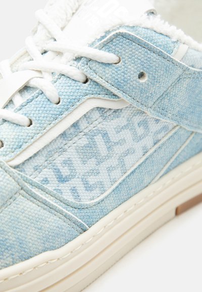 Ανοιχτό μπλε τζιν αθλητικό παπούτσι με λευκά κορδόνια, υφασμάτινη επιφάνεια με υφή και λευκή λαστιχένια σόλα που εμφανίζει μερικό γεωμετρικό σχέδιο στο πλαϊνό πάνελ.