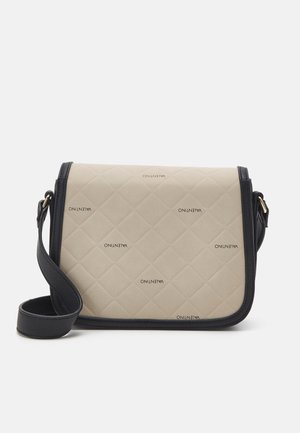 Beige quiltattu olkalaukku mustilla reunoilla ja hihnalla, jossa toistuu Valentino-logokuvio pinnalla.