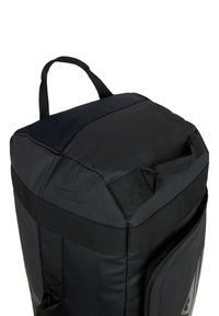 Black duffel bag with textured nylon fabric, rectangular shape, dual top handles, and a zippered side pocket for storage.