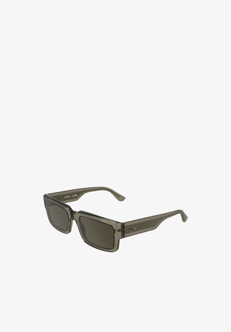 Lunettes de soleil rectangulaires avec une monture en plastique gris translucide et des verres foncés. Détails texturés sur la branche avec un logo.