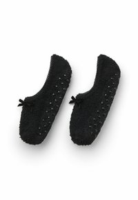 Černé huňaté pantofle s texturovaným povrchem, vyznačující se hladkými černými akcenty a malými mašličkami po stranách.