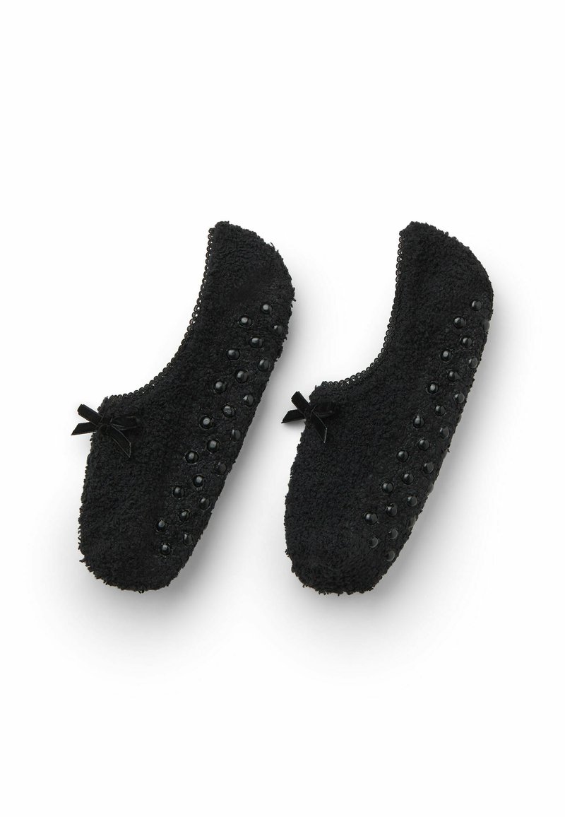 Černé huňaté pantofle s texturovaným povrchem, vyznačující se hladkými černými akcenty a malými mašličkami po stranách.