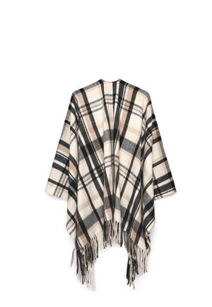 Poncho a quadri beige, nero e bianco con apertura frontale e orlo con frange, esposto appeso su sfondo bianco.