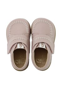 Zapatos de cuero rosa con punta redondeada, detalles cosidos y una cinta de velcro. Textura suave y suela de goma para mayor comodidad.