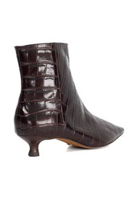 Brown crocodile-embossed ankle boot with a pointed toe, slim kitten heel, and shiny texture. Features a structured silhouette and minimal stitching.
