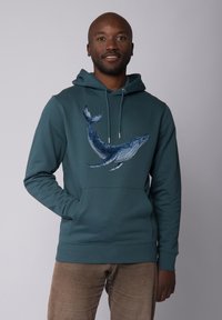 Teal hoodie met een walvisafbeelding op de voorkant, met trekkoorden en een voorkantvak. De stof lijkt glad, met een ontspannen pasvorm.