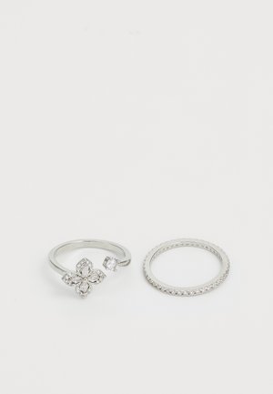 Set of two silver rings: one features a floral design with gemstones, the other is a simple band with small sparkling accents.