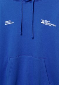 Felpa blu con cappuccio e cordini, con testo bianco "CREATING FULFILLING BACKGROUNDS" e "STWD DESIGN HOUSE" sul davanti. Include tasca frontale.