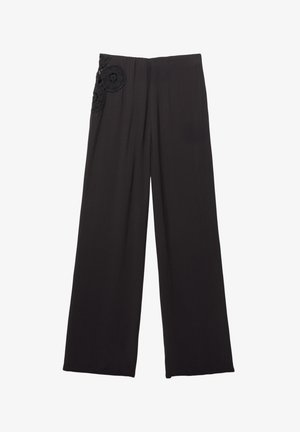 Schwarze weite Hosen mit glatter Textur, ausgestattet mit floralen Spitzenakzenten auf der linken Seite in der Nähe des Taillenbunds.