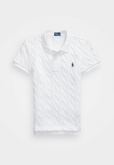 Balta polo krekls ar teksturētu adījumu, salocīta apkakle un īsām piedurknēm. Tam ir divi pogas un mazs tumši zils logo kreisajā krūtī.