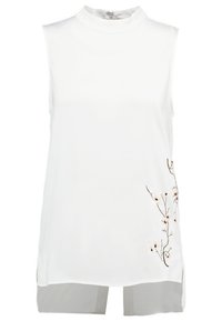 Blusa blanca sin mangas con un cuello alto, que presenta bordados florales en el lado izquierdo y paneles grises translúcidos en el dobladillo.