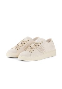 Baskets en daim beige avec un bout rond, un laçage à l'avant et un logo embossé subtil. Semelle en caoutchouc plate et détails texturés sur les côtés.