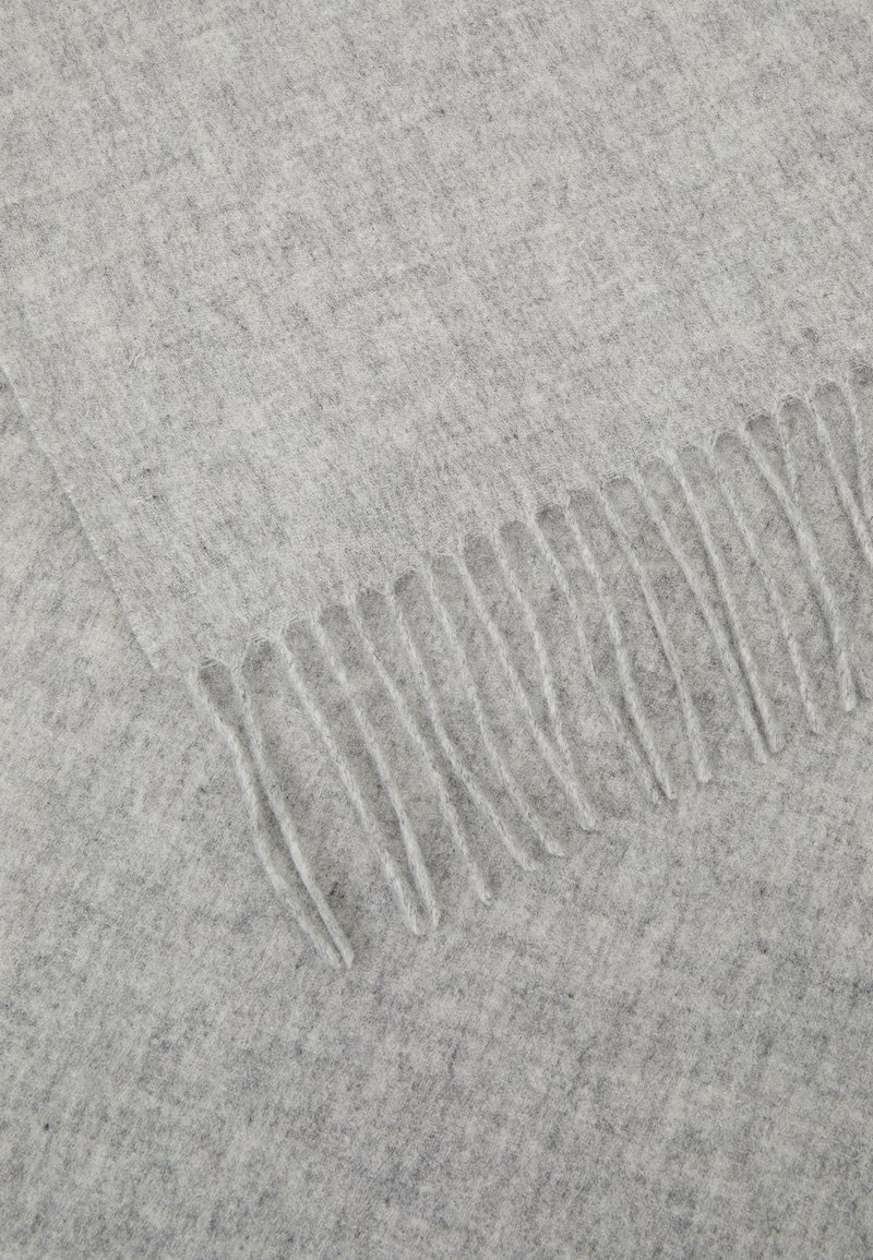 Grau Decke aus weichem Stoff mit strukturiertem Muster, mit fransigen Kanten zur Akzentuierung und einem subtilen, variierenden Grauton durchgängig.