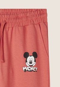 Pantalones de chándal de algodón coral con cintura elástica, que presentan un gráfico de Mickey Mouse en blanco y negro impreso en la pierna izquierda.