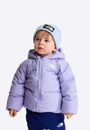 Tout-petit portant une doudoune violet clair, un pantalon bleu marine et un bonnet tricoté bleu clair, tous marqués du logo The North Face.