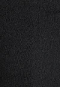Schwarzer Strickstoff, der eine glatte, strukturierte Oberfläche mit gleichmäßigen Stichen zeigt und sich für Bekleidung wie Strumpfwaren oder Leggings eignet.