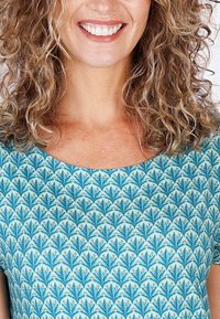 Musterbluse in Blau mit floralem Design in Türkistönen, runder Ausschnitt und kurzen Ärmeln. Glatte Textur.