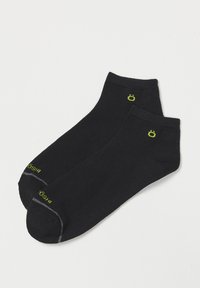 Calcetines negros hasta el tobillo, hechos de un material suave, con un logo verde en el tobillo y acentos grises en la punta.