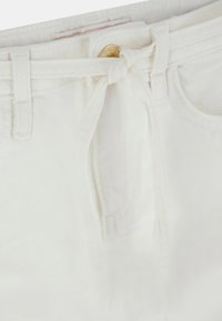 Shorts di denim bianchi con un dettaglio della cintura annodata, zip frontale e cuciture sottili. Presentano un classico design a cinque tasche.