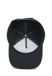 Cappello nero con un design strutturato e visiera piatta. All'interno presenta una fodera bianca e un'etichetta stampata con la scritta "THE FARM". La texture sembra liscia.