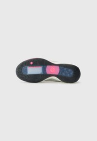 La semelle de la chaussure présente une base en caoutchouc noir avec un motif texturé, des accents roses et une section de coussin d'air transparent étiquetée « AIR ZOOM ». 