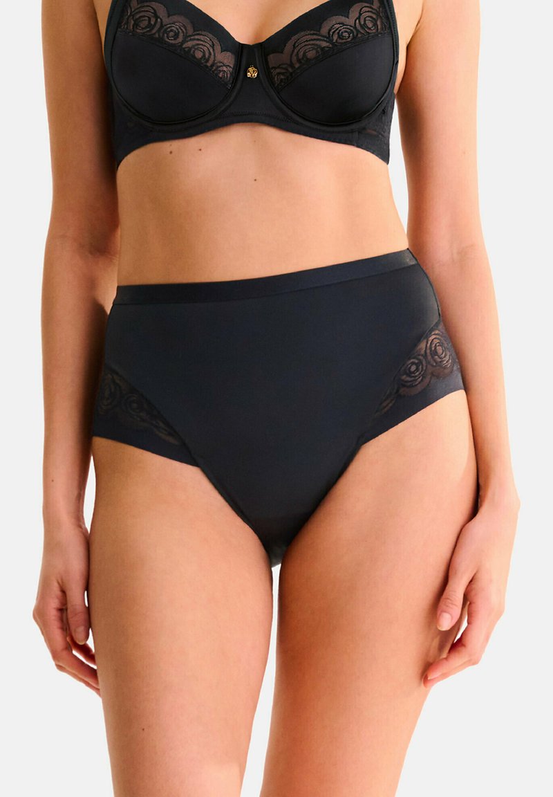 Zwarte high-waist onderbroek en bijpassende BH met doorschijnende kanten accenten en bloemige borduursels. Glad stof, zachte textuur en elastische tailleband.