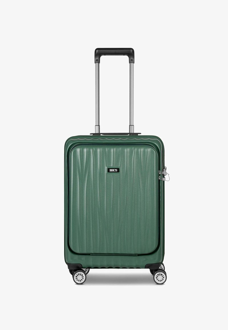 Valigia rigida verde con scanalature testurizzate, manico telescopico, quattro ruote bianche e patch con logo. Materiale resistente per l'uso durante i viaggi.