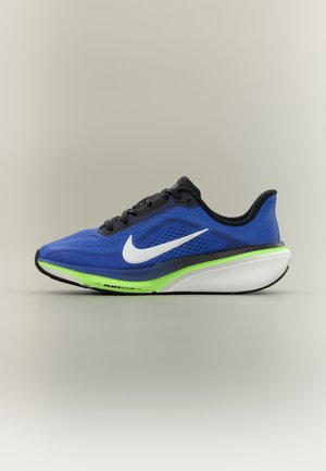 Blauwe en zwarte Nike hardloopschoen met witte Nike-vink, neon groene en witte zool, en de tekst "Air Zoom" op de tussenzool.