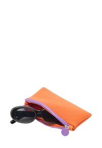 Pomarańczowe etui na okulary przeciwsłoneczne z neoprenu z fioletowym zamkiem; częściowo widoczne czarne okulary przeciwsłoneczne w środku. Brak wzorów lub dodatkowych elementów metalowych.