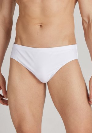 Weiße Schwimmbörsen mit einer glatten Textur und einem niedrigen Schnitt, die einen minimalistischen Stil und einen elastischen Bund aufweisen.