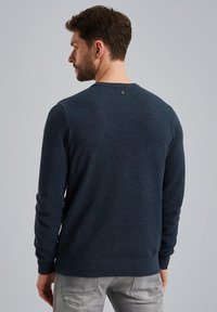 Marineblaues strukturiertes Strickpullover mit rundem Ausschnitt und langen Ärmeln. Verfügt über ein kleines Logo-Detail am hinteren Ausschnitt.
