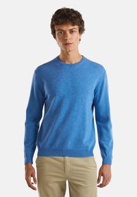 Niebieski sweter z dzianiny, z okrągłym dekoltem i długimi rękawami, o subtelnej teksturze oraz prążkowanych mankietach i dolnym wykończeniu.