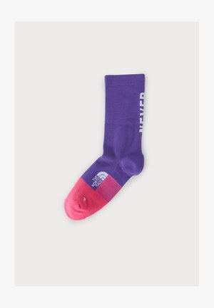 Chaussette violette et rose avec le logo The North Face près des orteils et texte blanc partiel visible sur le côté.