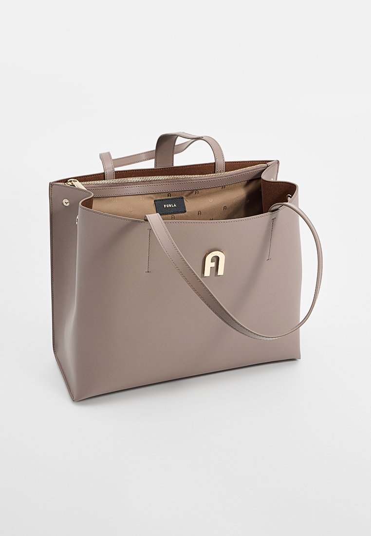 Helle taupe Leder-Tote mit goldfarbener Hardware, doppelten Obergriffen und einem Reißverschlussverschluss. Verfügt über ein markiertes Innenfutter.