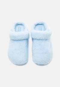 Világoskék, bolyhos papucsok lekerekített formával és hajtott mandzsettával. Puha tapintású, látható minták nélkül, a kényelem érdekében tervezték.